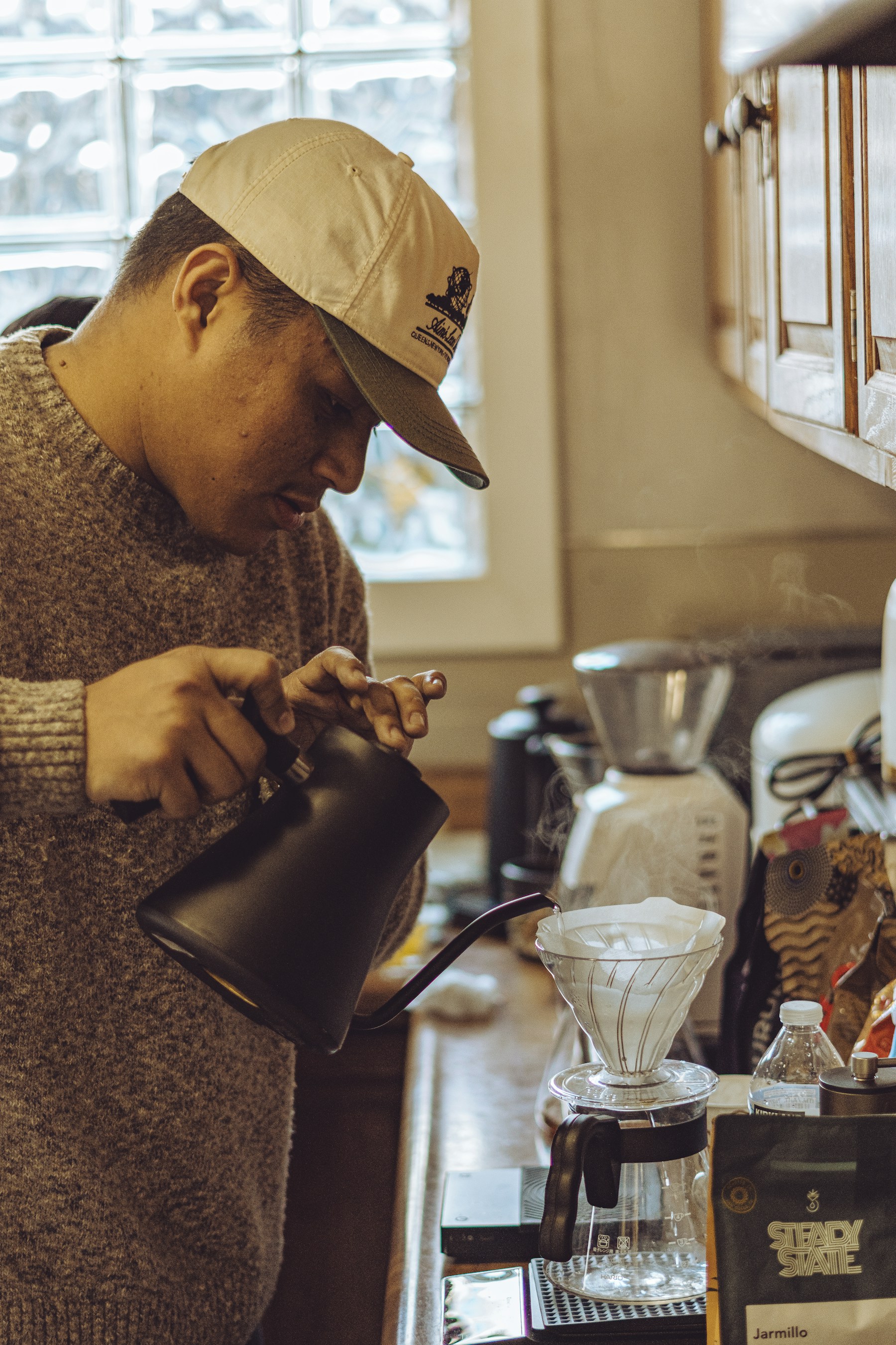 A man pouring a cup of coffee in a kitchen