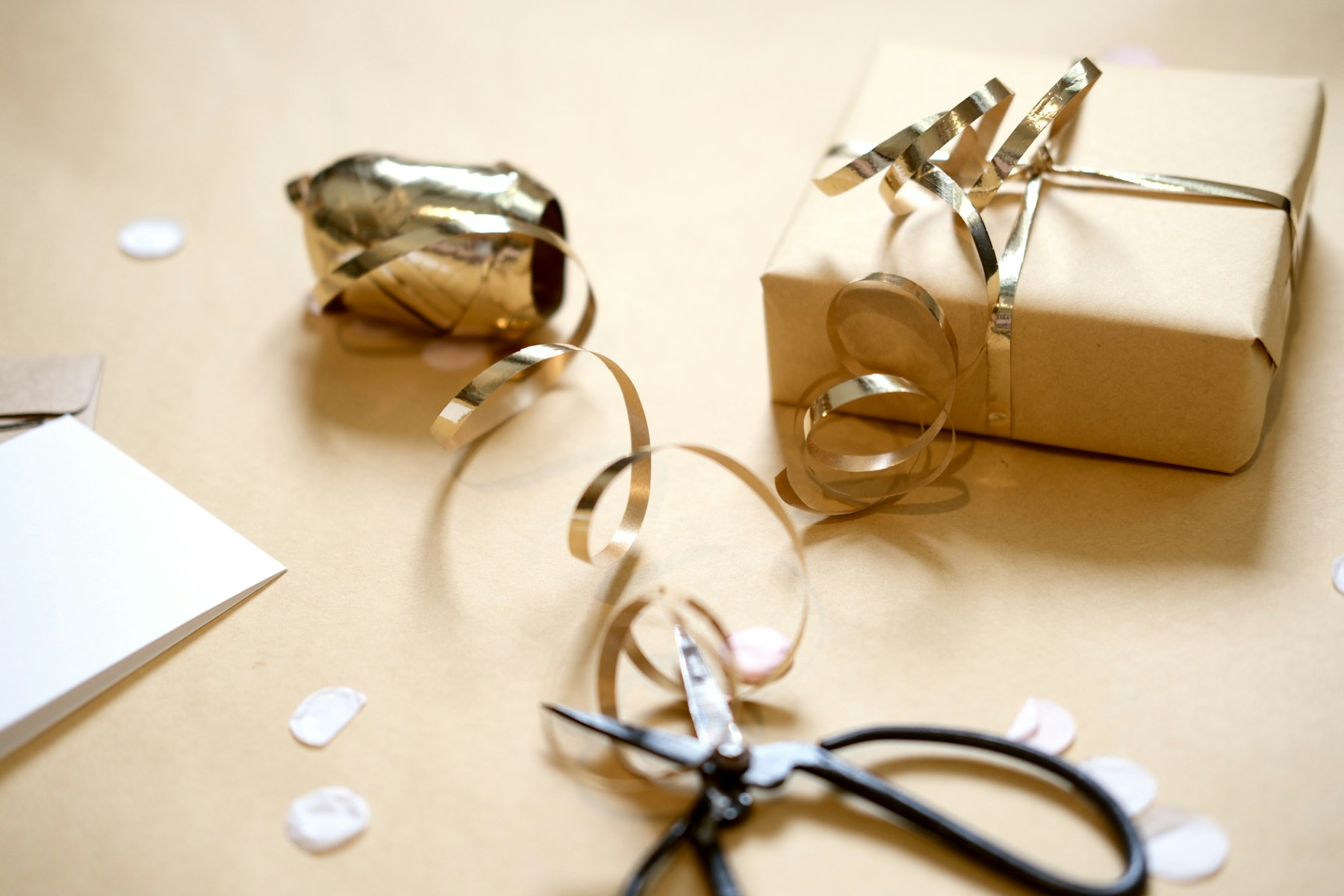 Gift wrapping with scissors, ribbon, and paper.