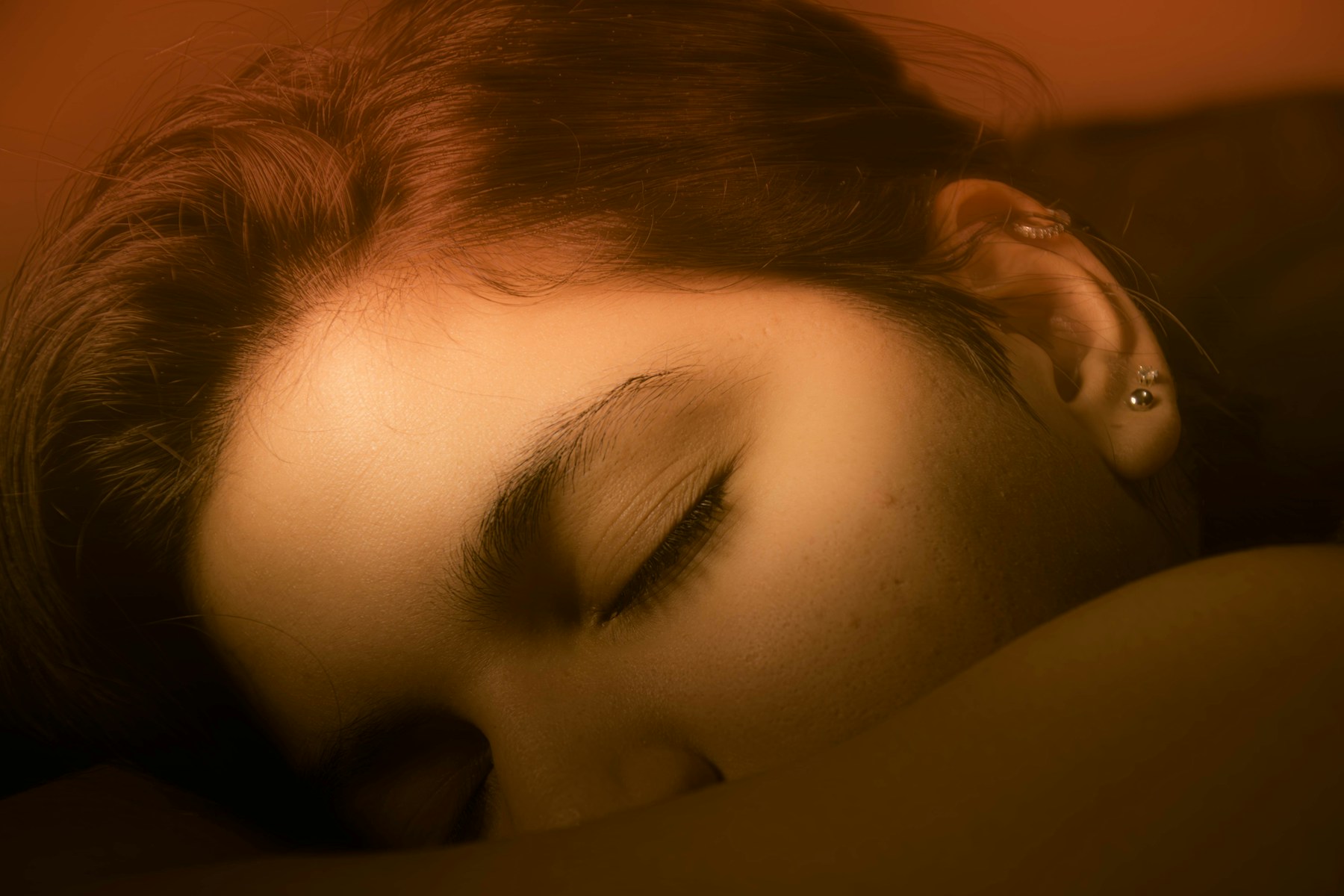 A woman sleeping on a bed with her eyes closed