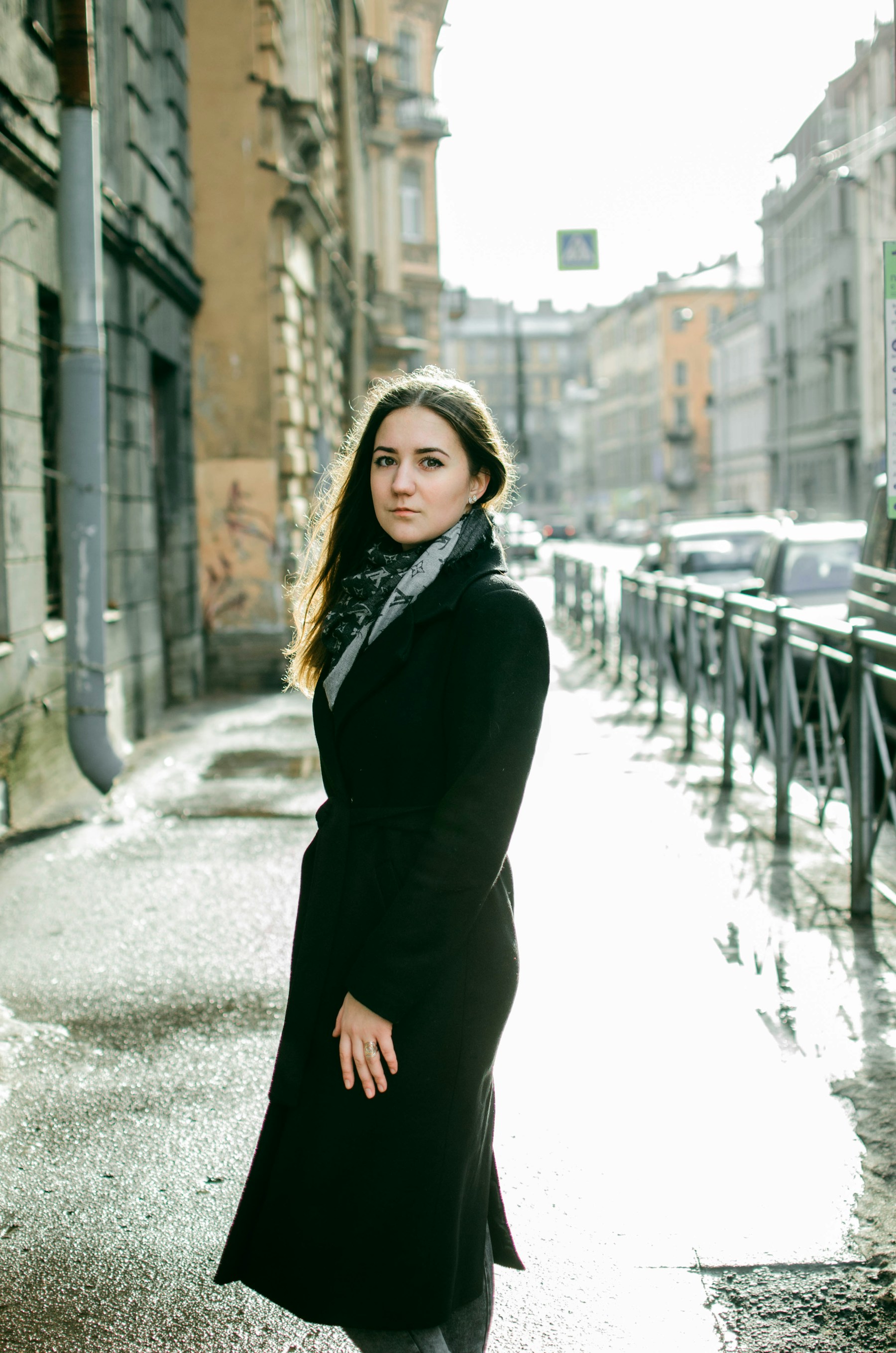 woman in wrap coat standing at the street